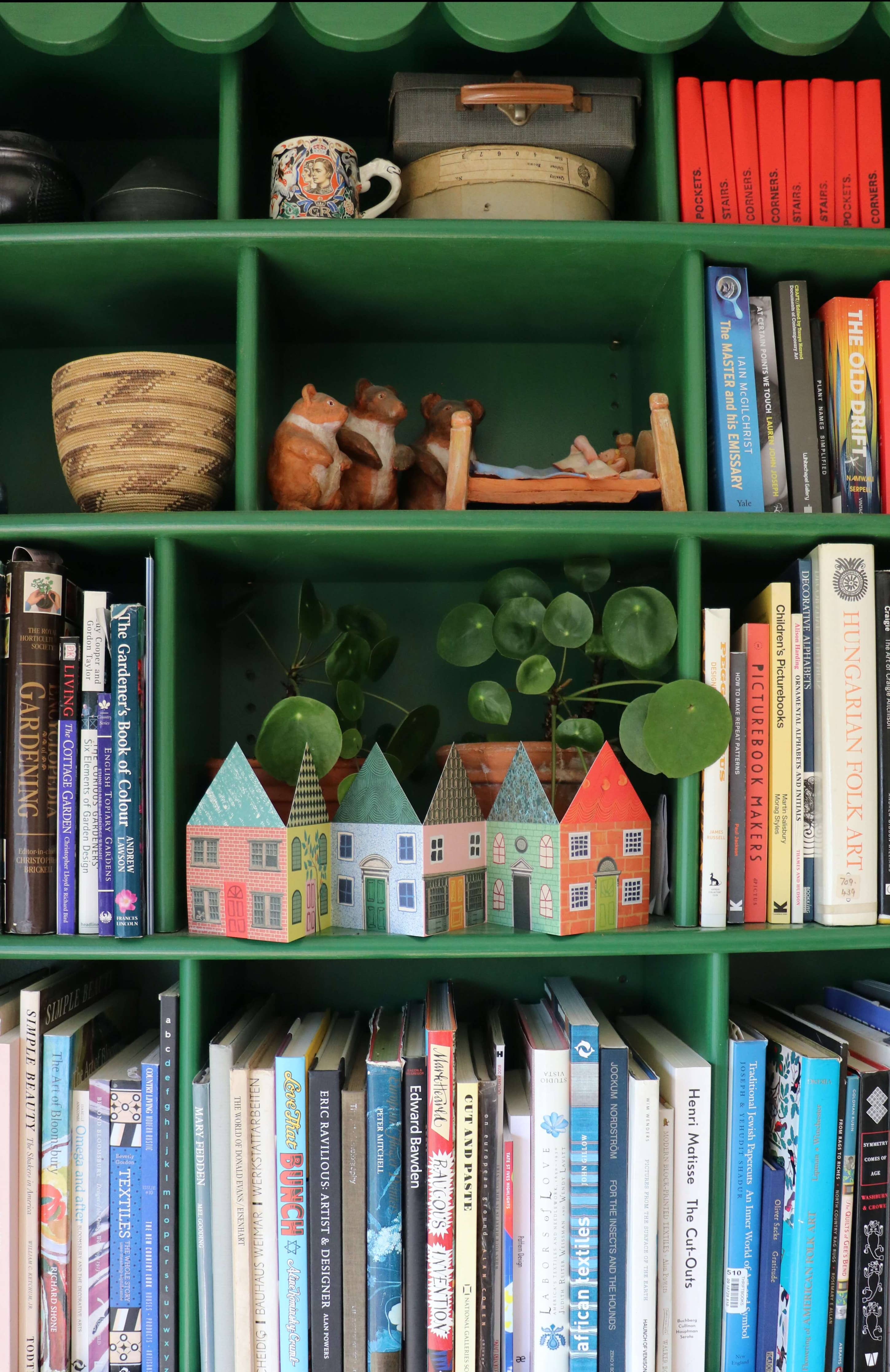 Bookshelf with books and decorative items including small model houses.