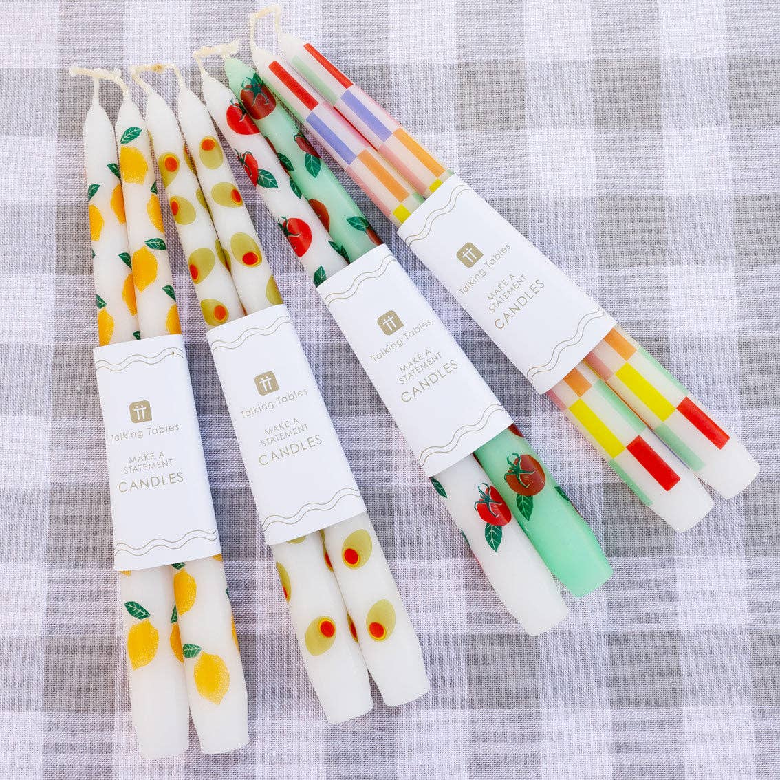 Set of colorful candles with decorative designs on a checkered background