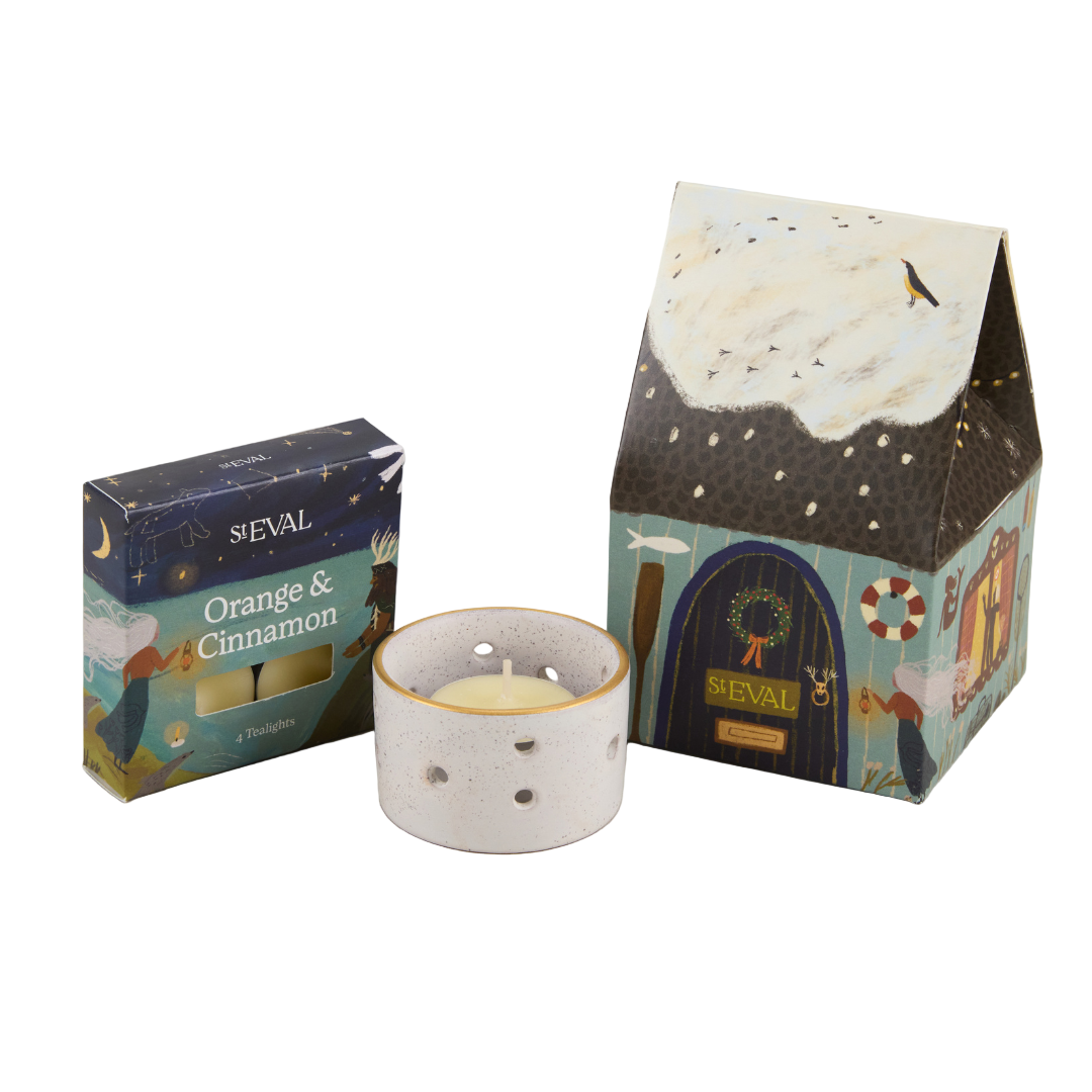 Candle with decorative packaging and 'Orange & Cinnamon' label on a white background