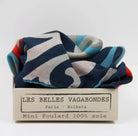 Colorful scarf in a box with 'Les Belles Vagabondes' branding on a white background