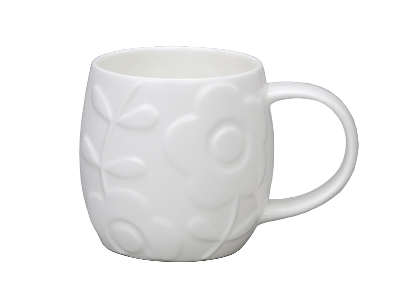 White ceramic mug with embossed design on a gray background