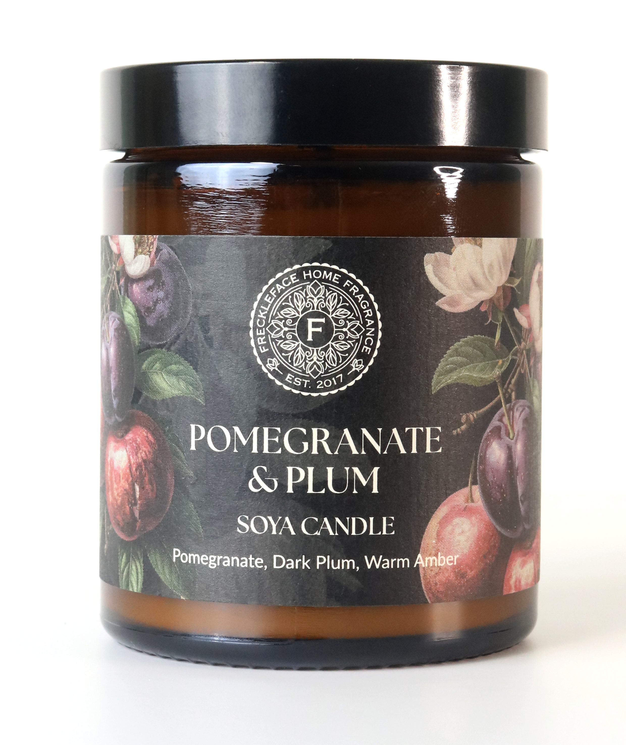 Pomegranate & Plum soy candle with decorative label on a white background