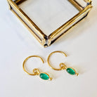 Gold hoop earrings with agate stones on a white background