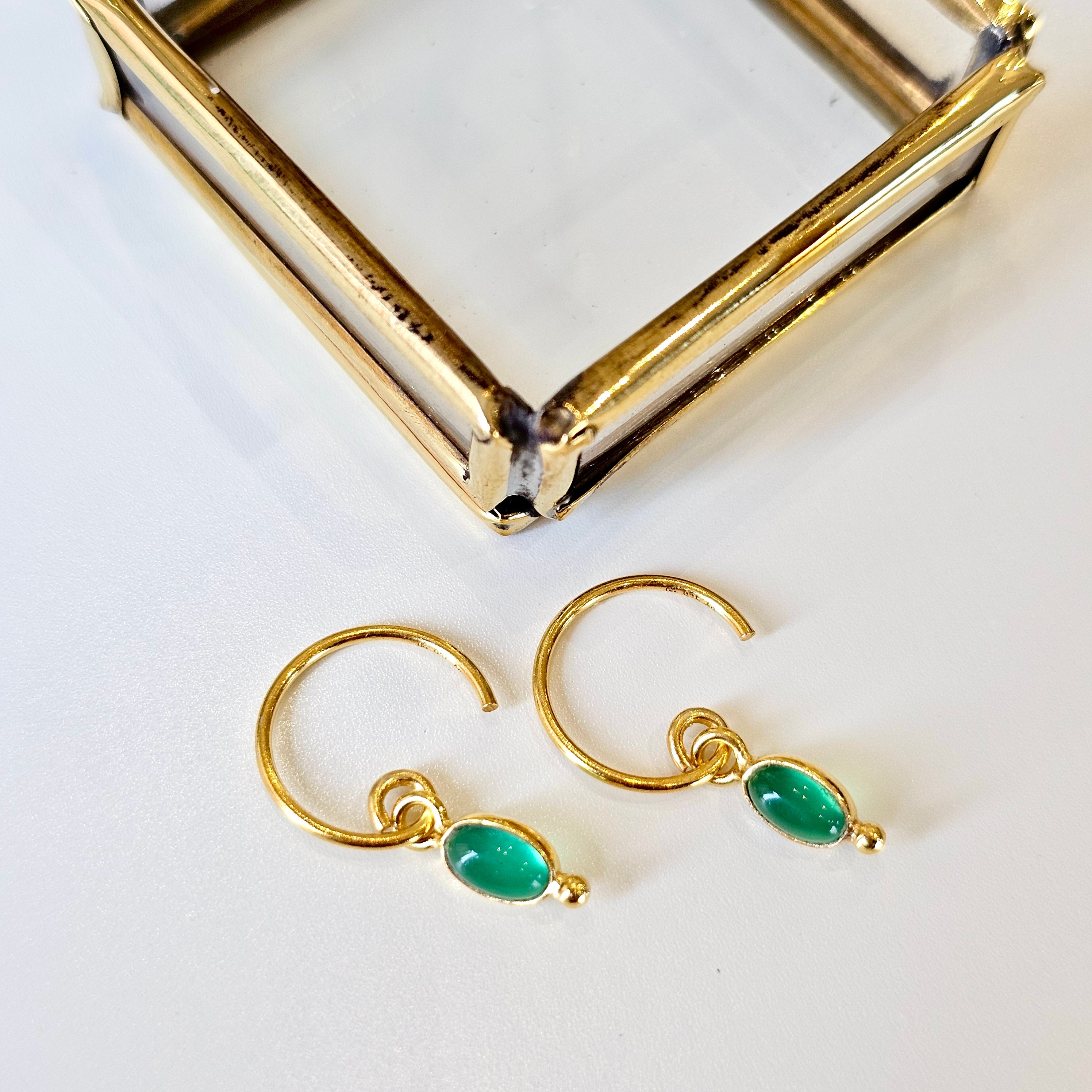 Gold hoop earrings with agate stones on a white background