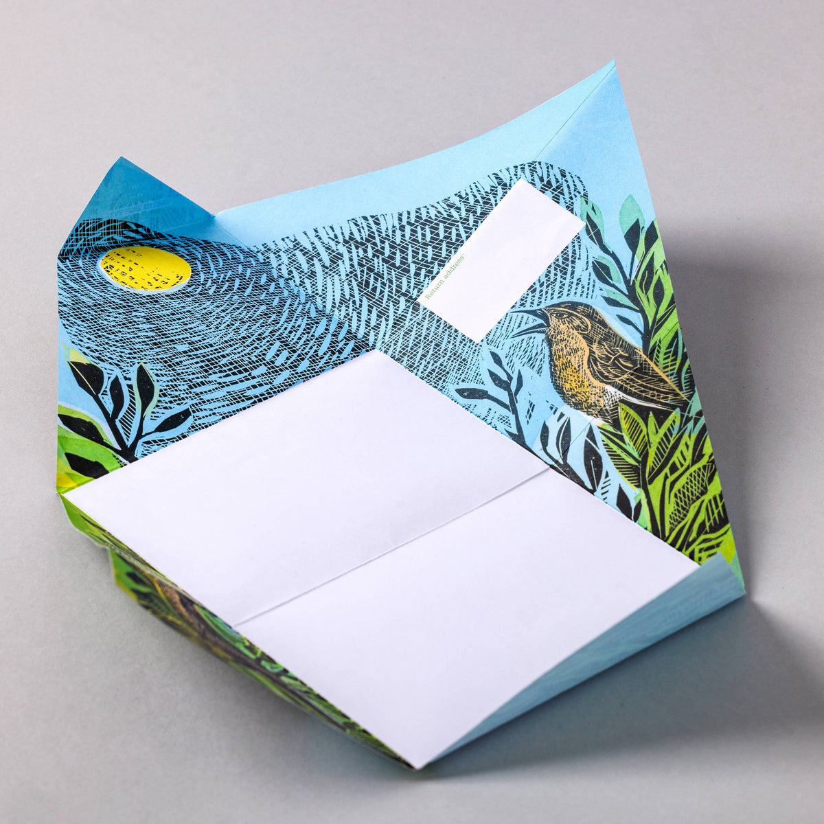 Folding letter set with nature-themed cover featuring a bird and leaves on a grey background