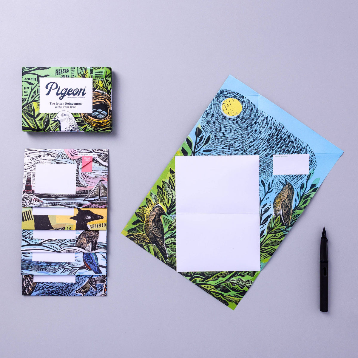 Letter set with artistic covers and a pen on a grey background