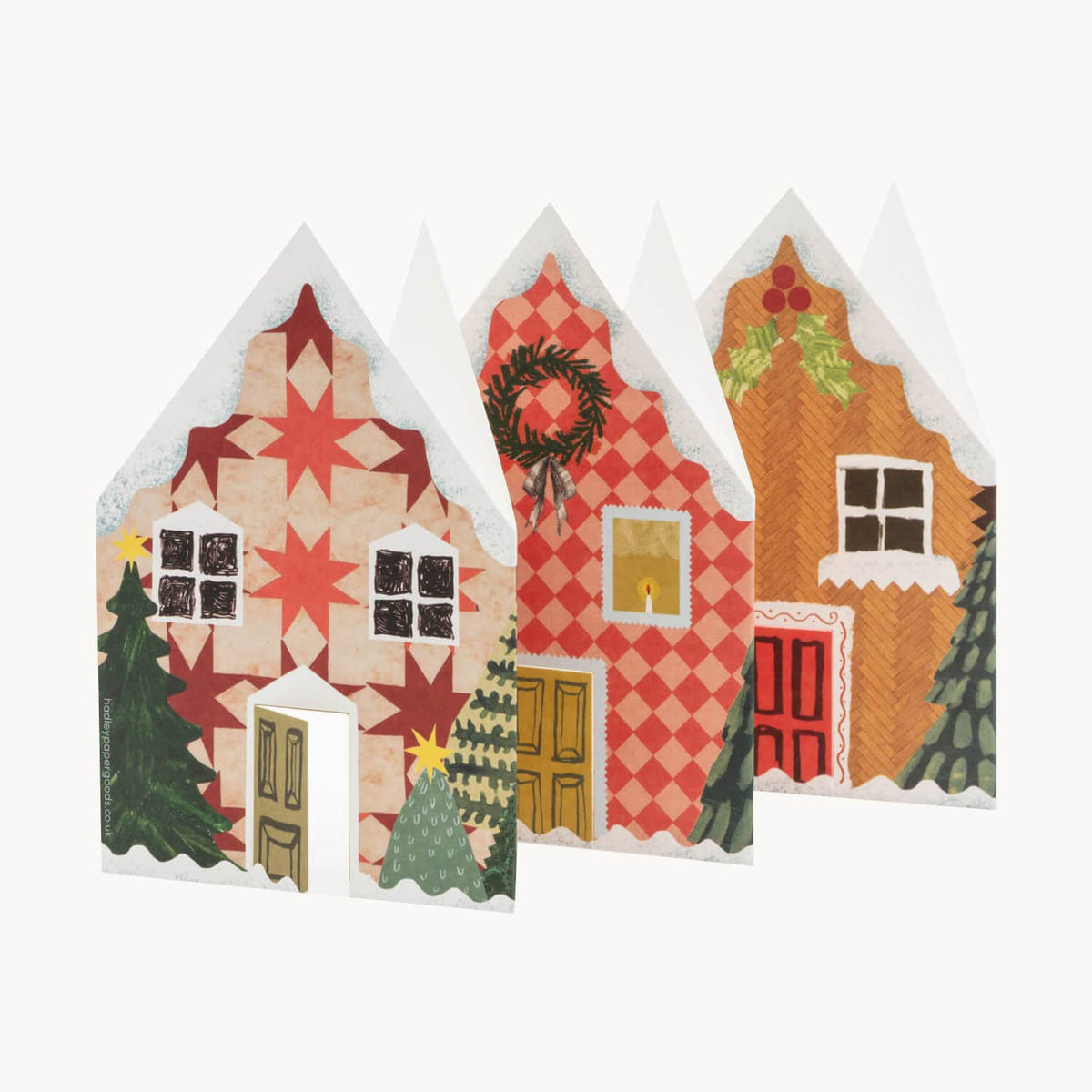 Christmas houses card with patterned roofs and festive details, shown folded and standing on a plain light background