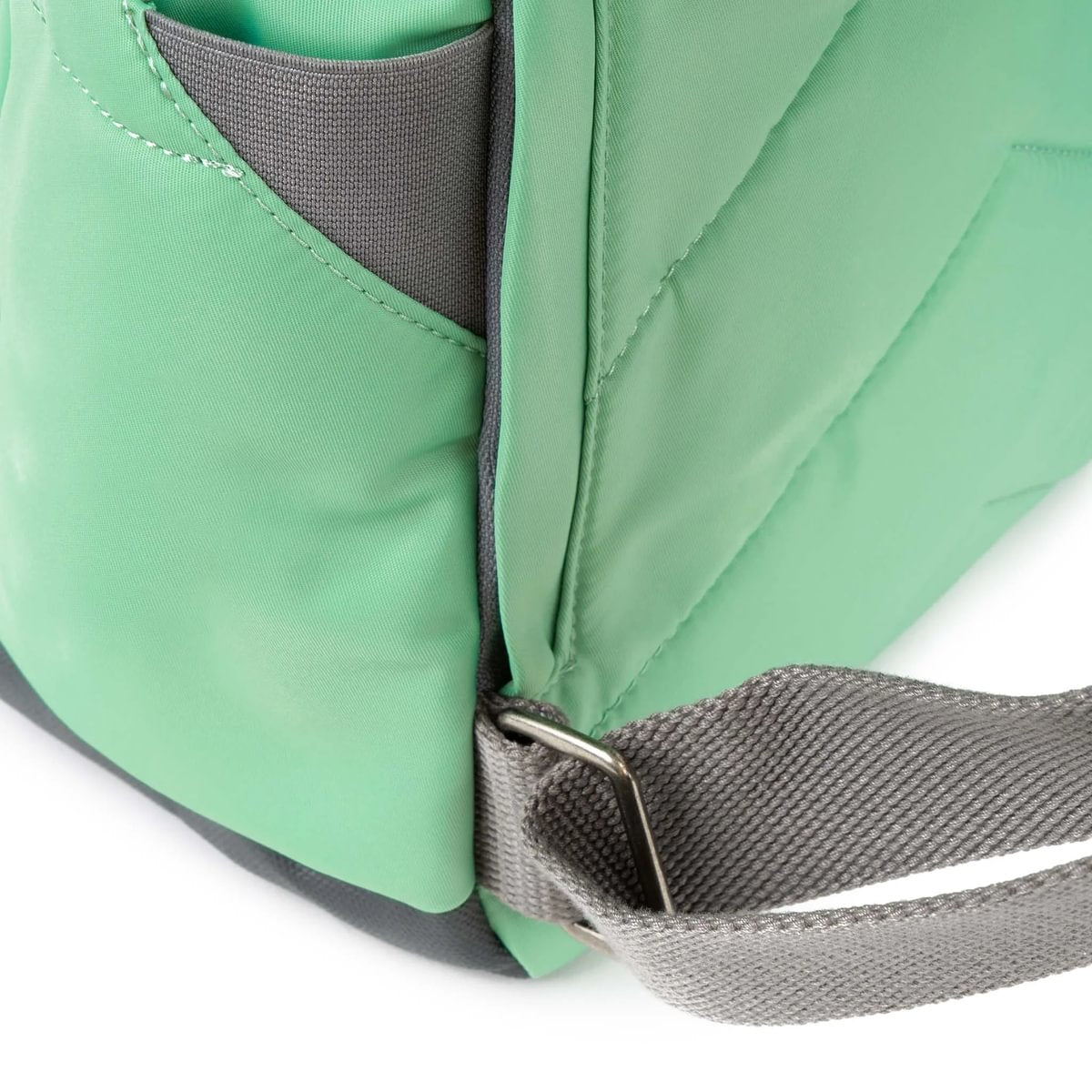 Close-up of a green bag with a grey strap on a white background