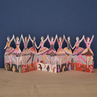 Decorative paper cutout card of ballerinas in a row on a wooden surface with a blue background