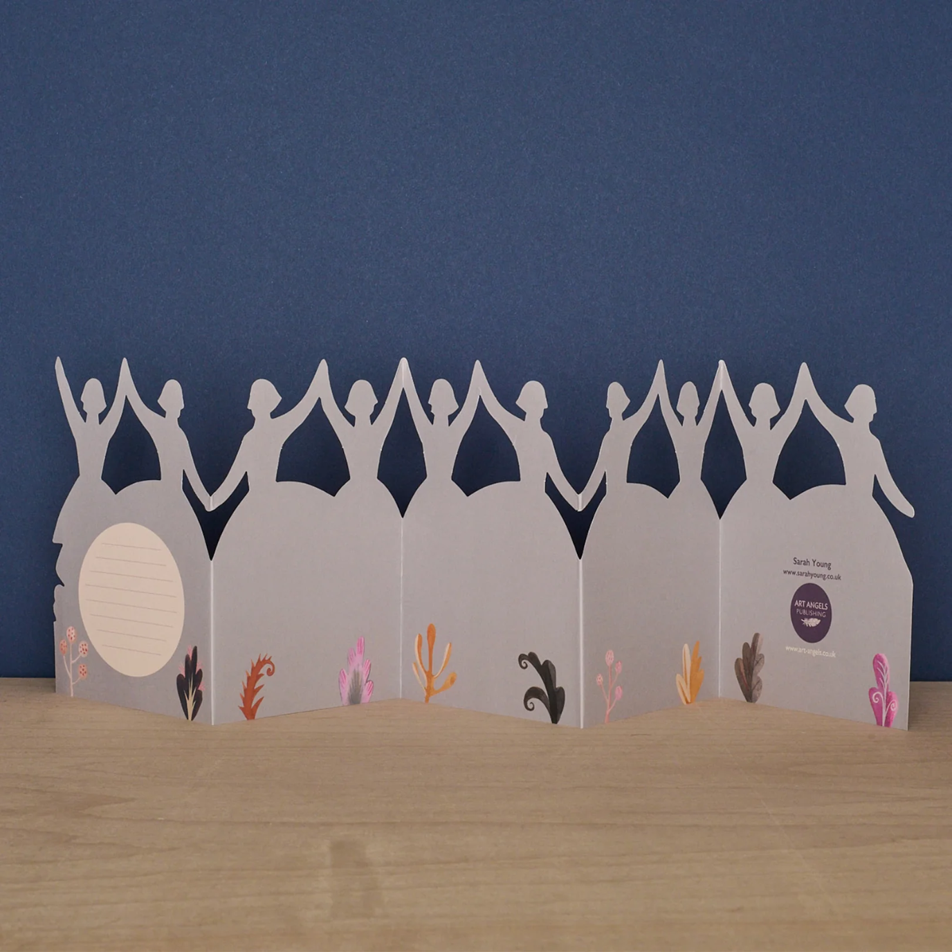 Card with cut-out figures holding hands against a blue background