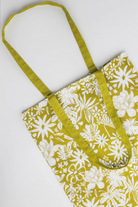 Floral-patterned bag with green strap on a white background