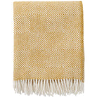 Yellow patterned throw blanket with white fringe on a white background