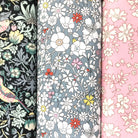 Three floral fabric hankies in black, grey and pink.