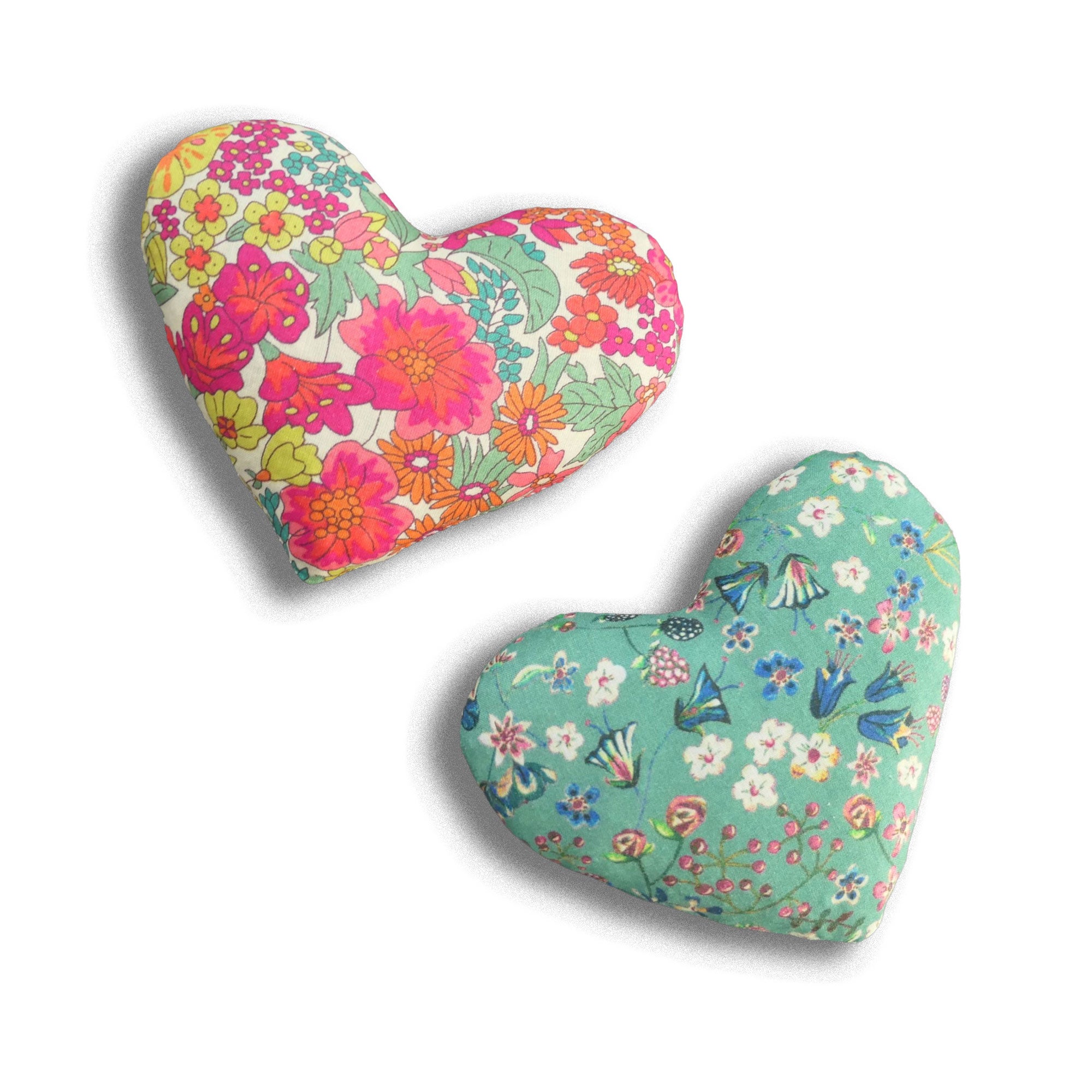 Two heart-shaped cushions with floral patterns on a white background