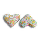 Two heart-shaped pillows with floral patterns on a white background