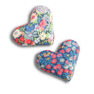 Two heart-shaped floral cushions on a white background