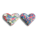 Two heart-shaped sachets with floral patterns in blue and red on a white background