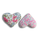 Two heart-shaped lavender bags with pink floral patterns on a white background