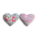 Two heart-shaped fabric sachets with floral patterns on a white background