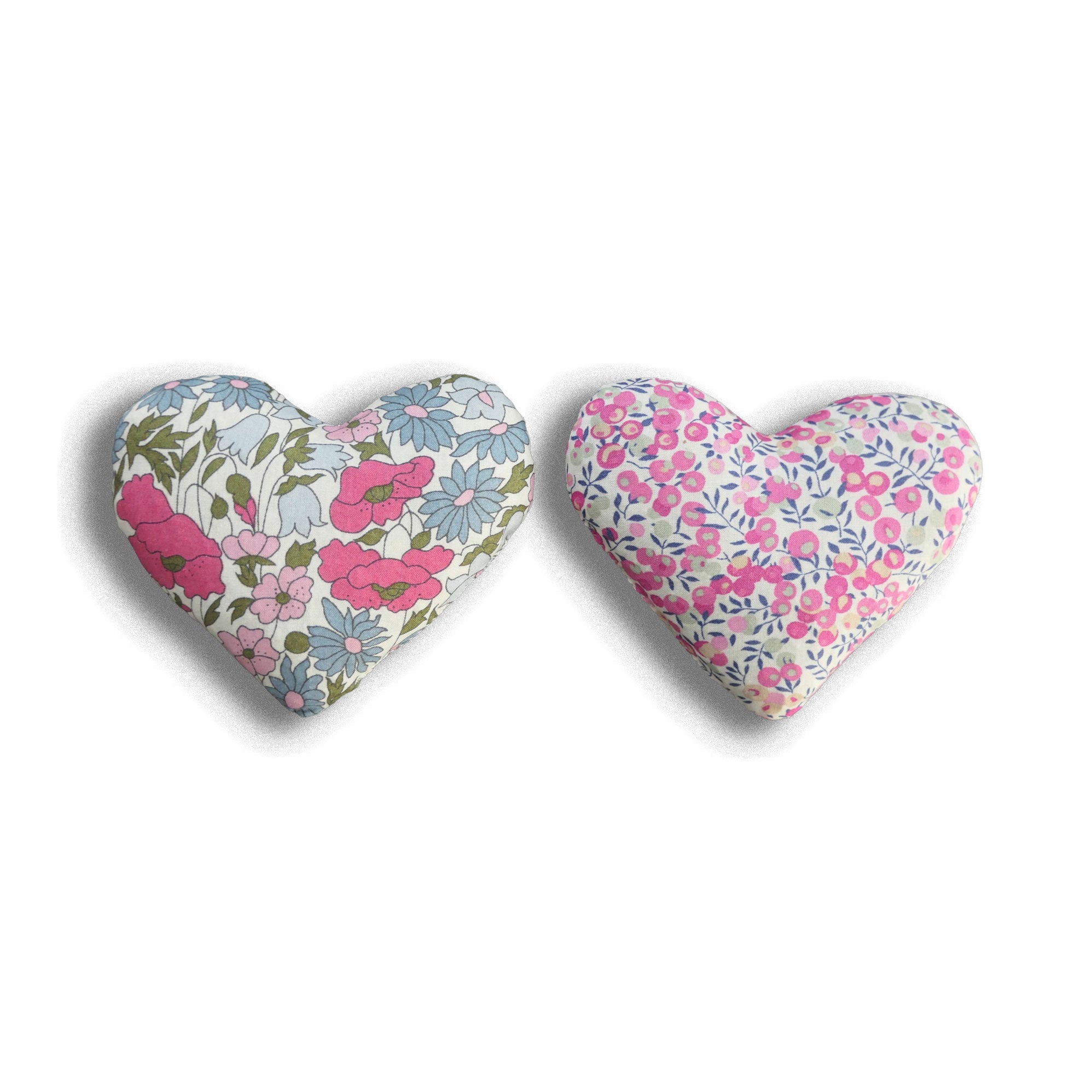 Two heart-shaped fabric sachets with floral patterns on a white background