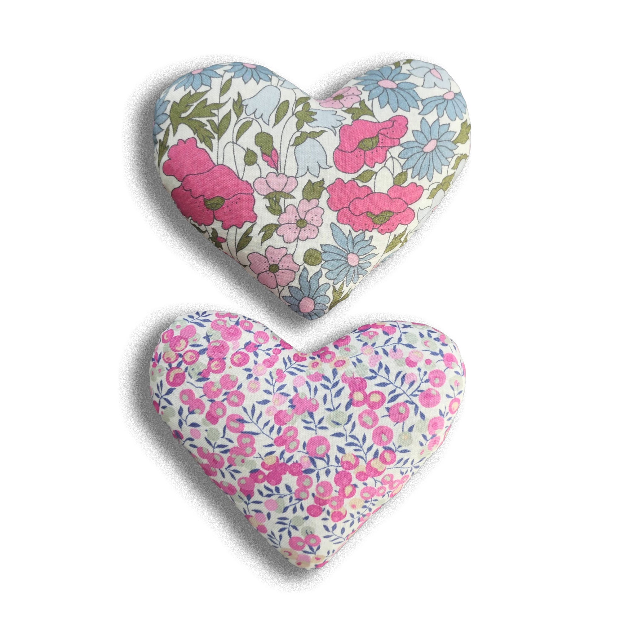 Two heart-shaped floral cushions on a white background