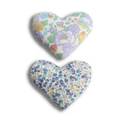 Two heart-shaped pillows with floral patterns on a white background