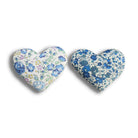 Two heart-shaped cotton and lavender sachets with floral patterns on a white background