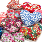 Heart-shaped fabric lavender cushions with colourful floral patterns on a white background