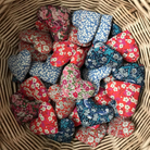 Collection of floral heart-shaped fabric lavender pillows in a wicker basket