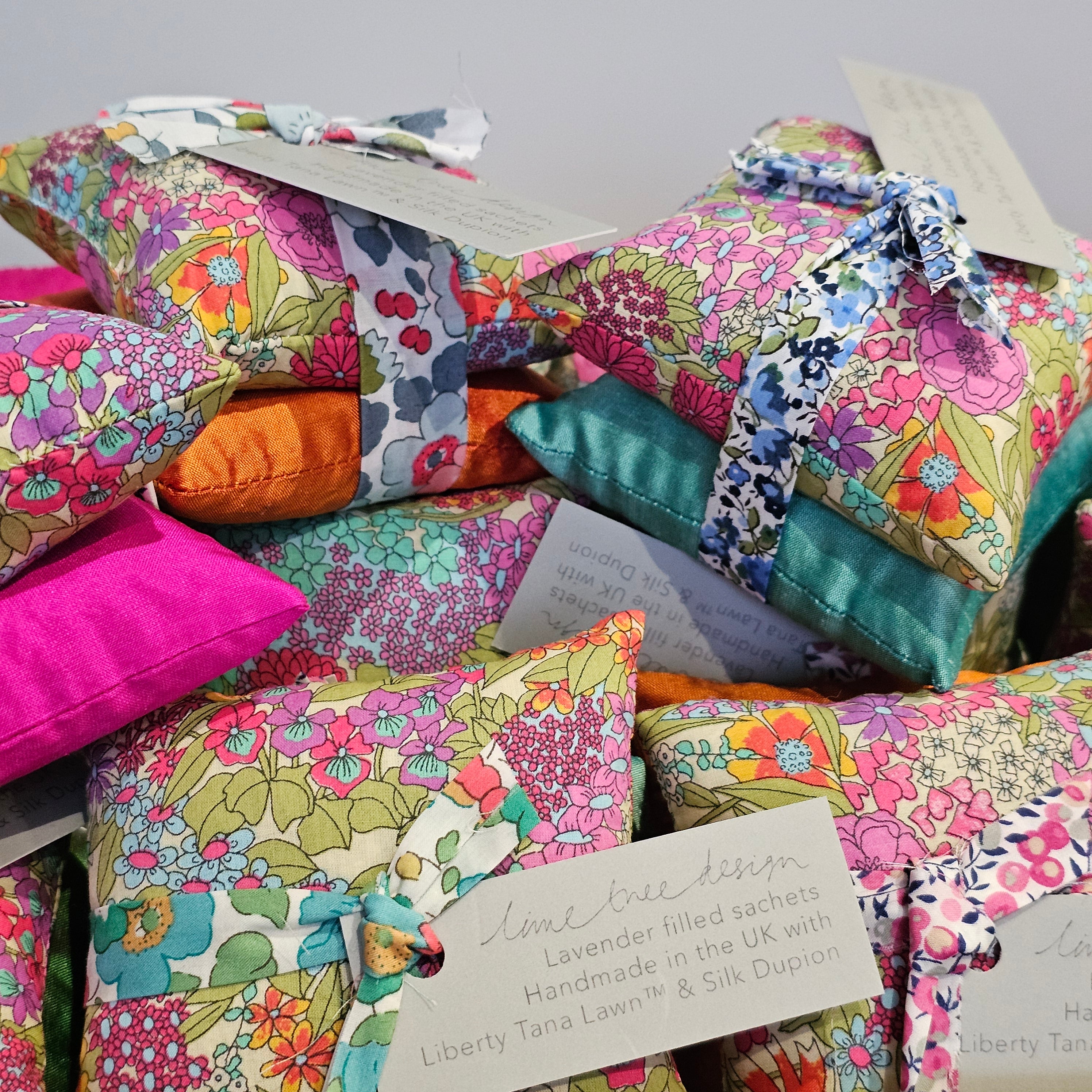 Colourful fabric pillows with floral patterns on a gray background