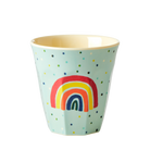 Light blue cup with rainbow design and polka dots on a white background