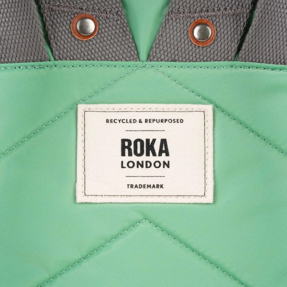 Close up of a green bag with a Roka London label 