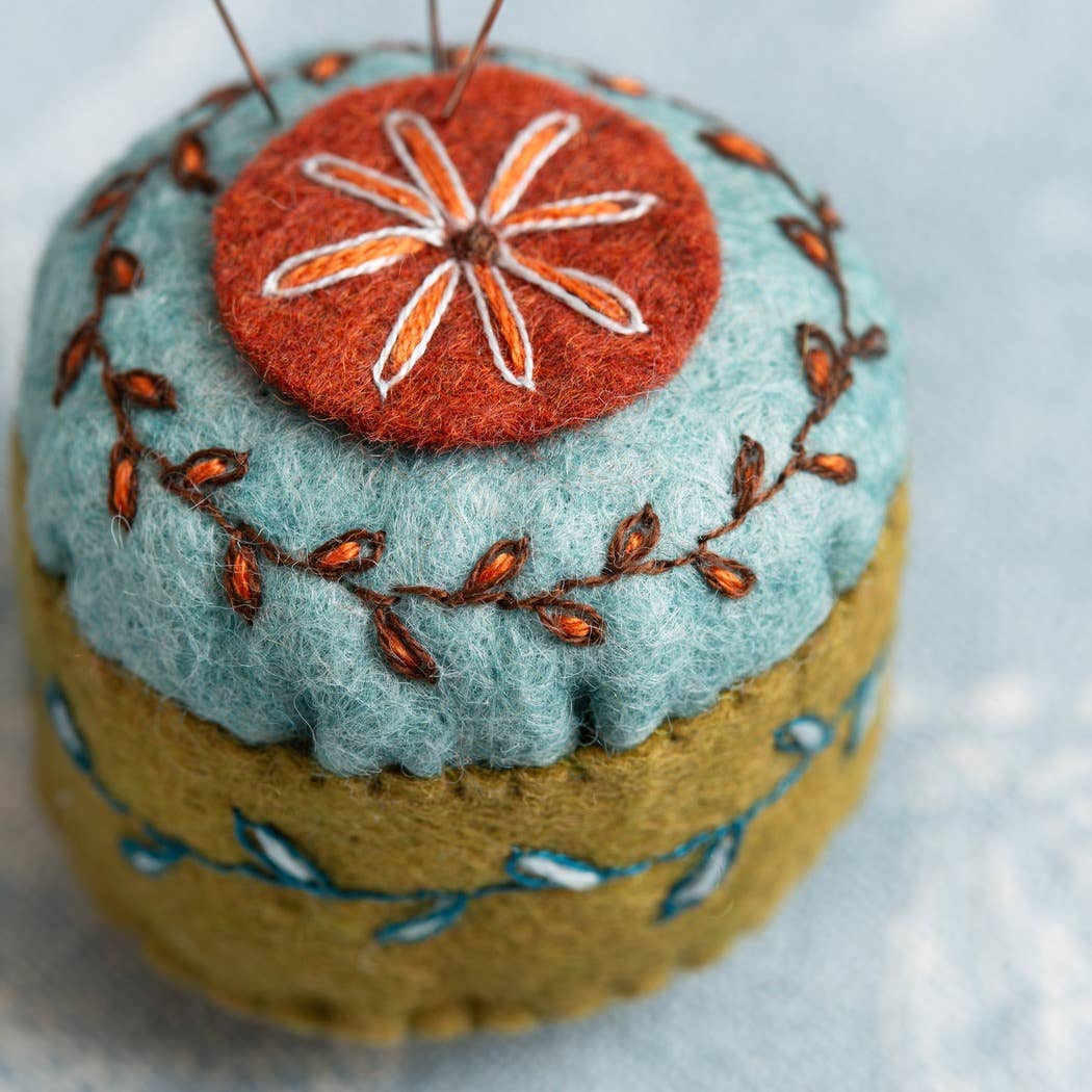 Embroidered felt mini pin cushion made with coral red, light blue and olive green felt.