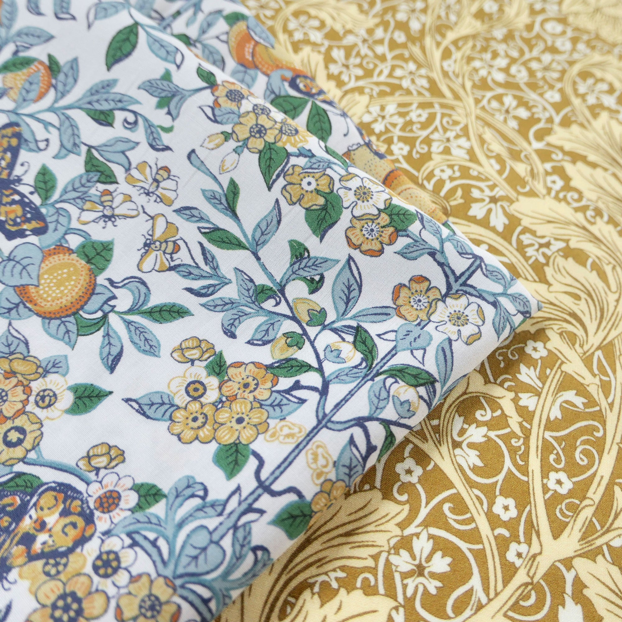Close-up of floral fabric hanky with blue, yellow, and green colours on a white background.