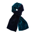 A double-sided velvet scarf in deep teal and navy blue, styled in a loop on a solid white background.