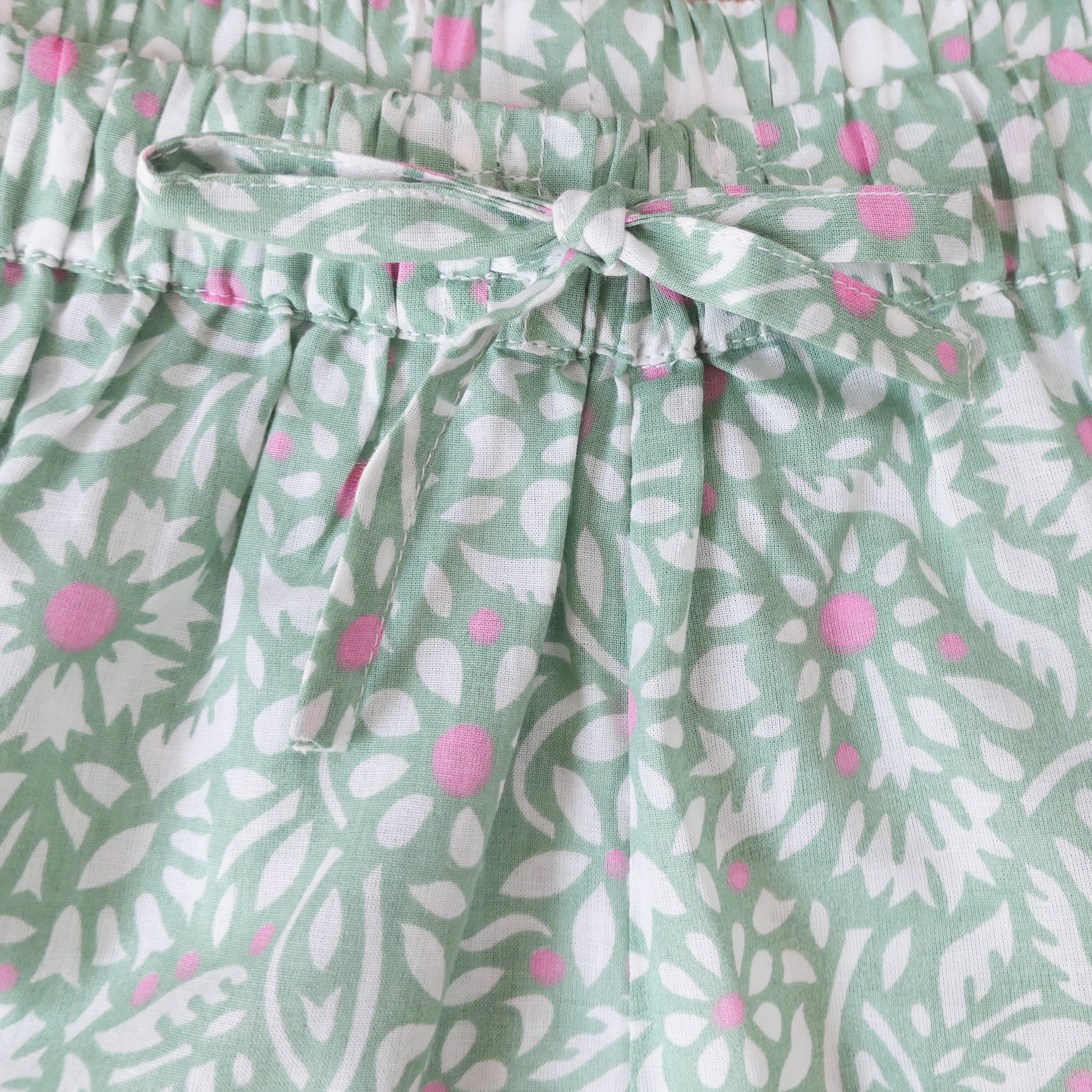 Close-up of a green floral patterned fabric with a tie.