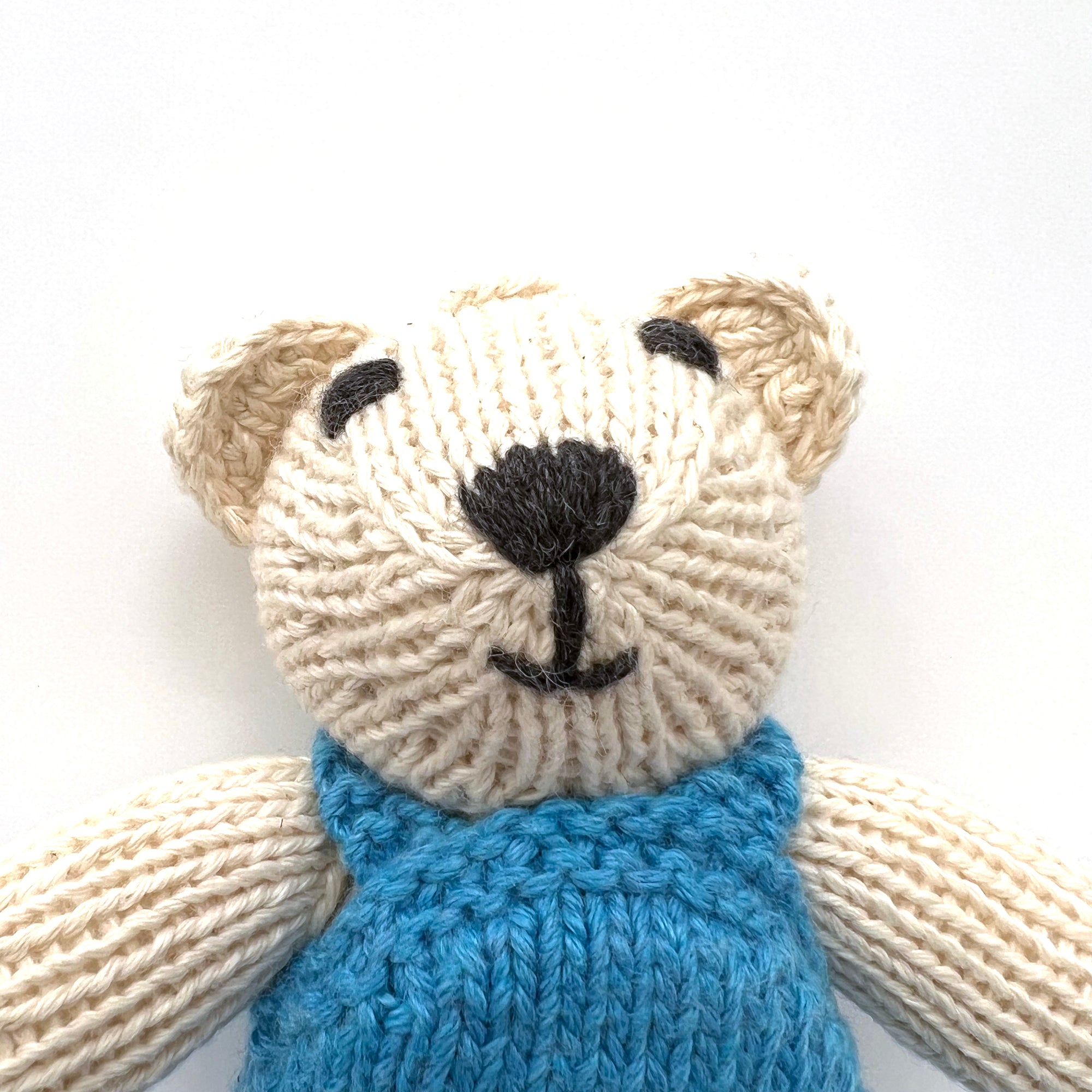 knitted soft toy polar bear in blue dungarees