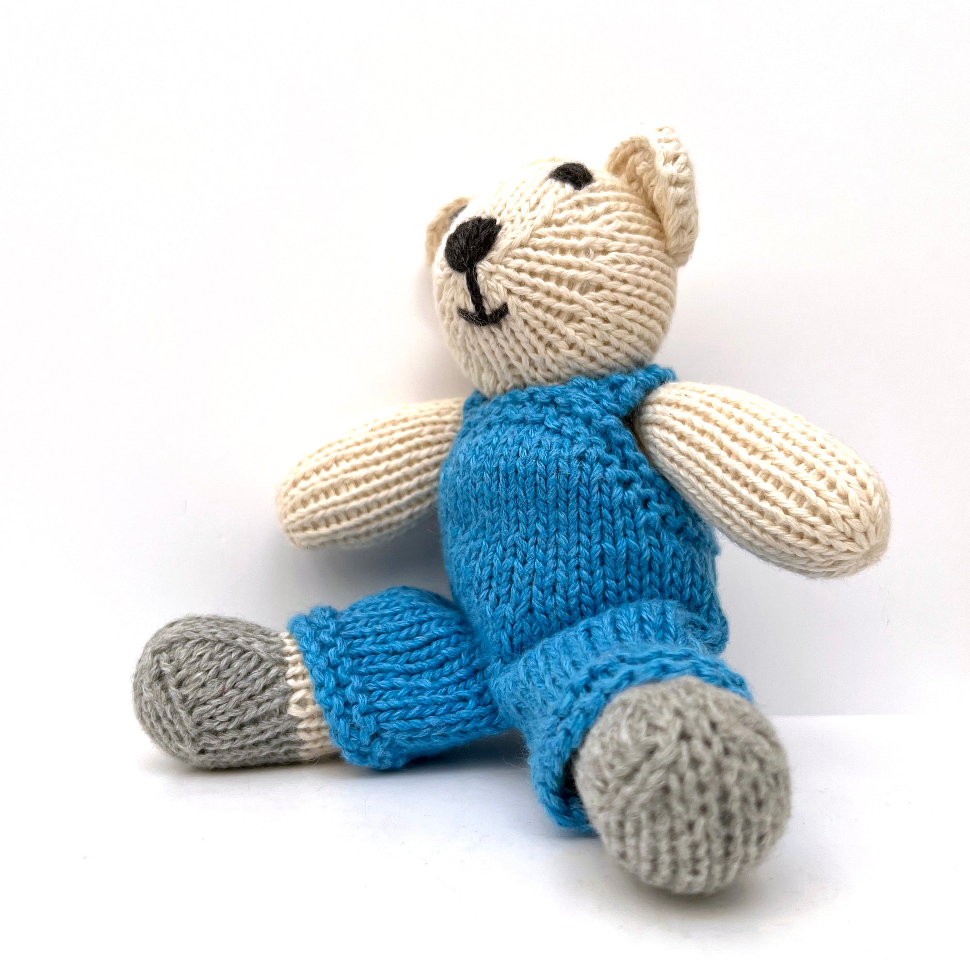 knitted soft toy polar bear in blue dungarees