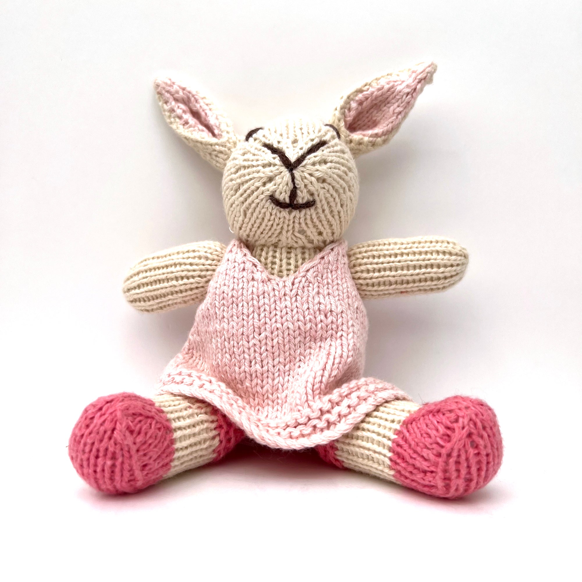 knitted soft rabbit toy in a pink dress 