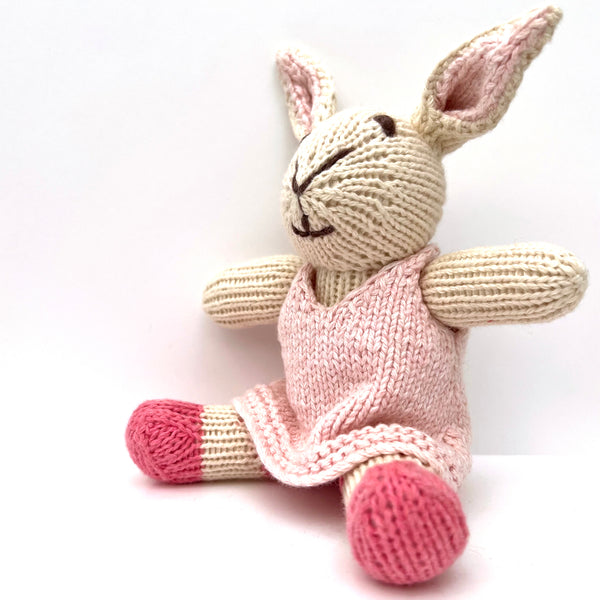 knitted soft rabbit toy in a pink dress 