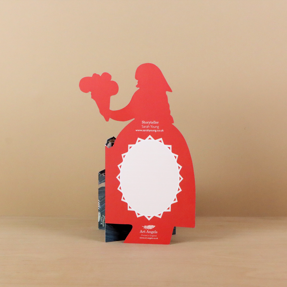 Red silhouette standee of a storyteller with a white circle for a face on a beige background