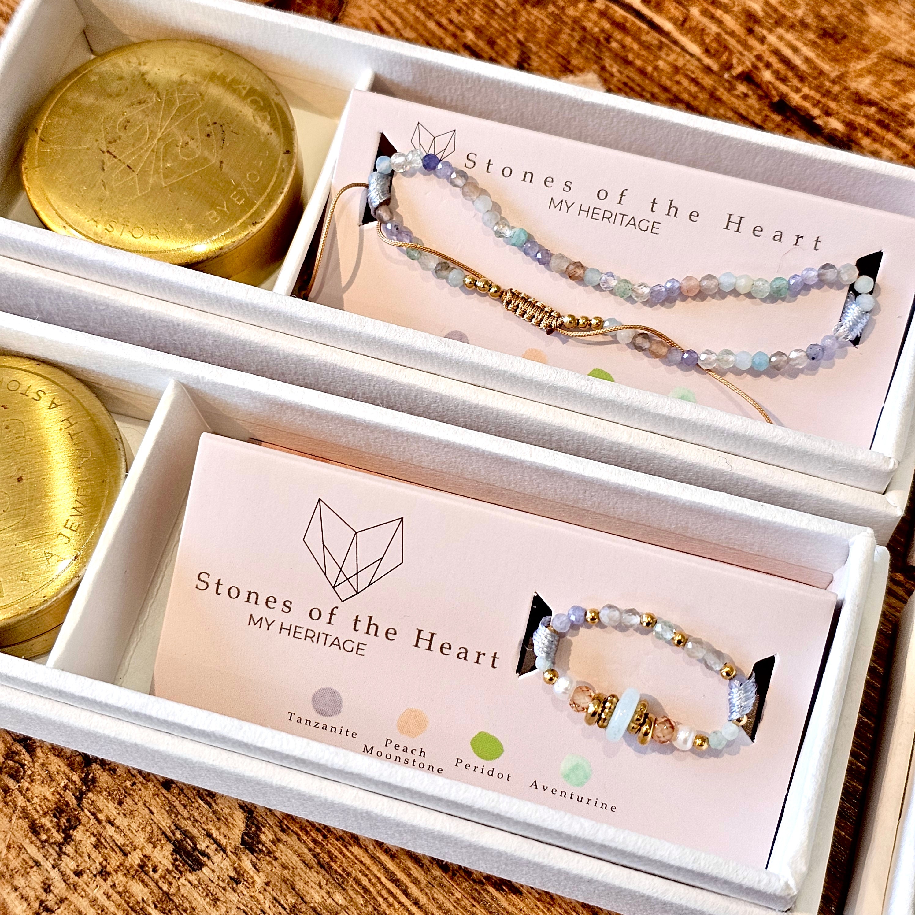 Bracelet and ring in 'Stones of the Heart' boxes on a wooden surface