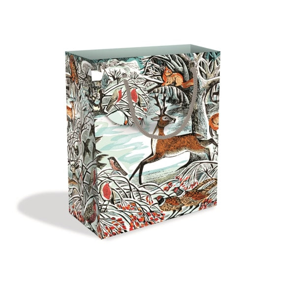 Image of a gift bag with a grey cord handle and round tag. Design is winter in nature themed featuring deer, squirrels, robins, pheasants in a snowy field surrounded by trees. 