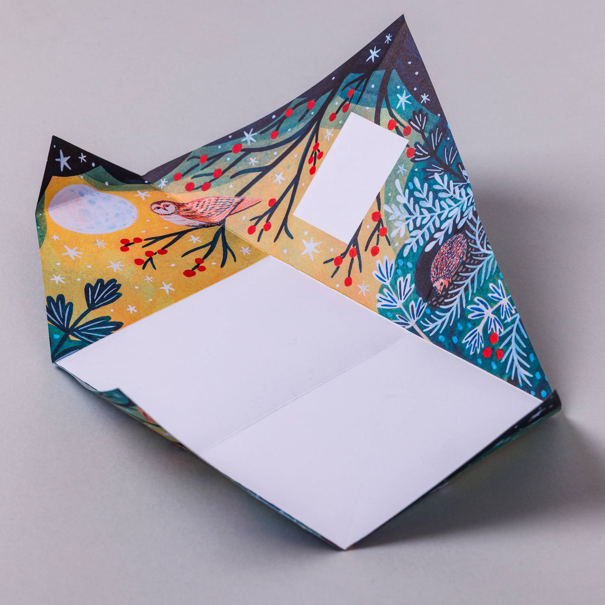 Colourful folded letter paper with nature-themed design on a grey background