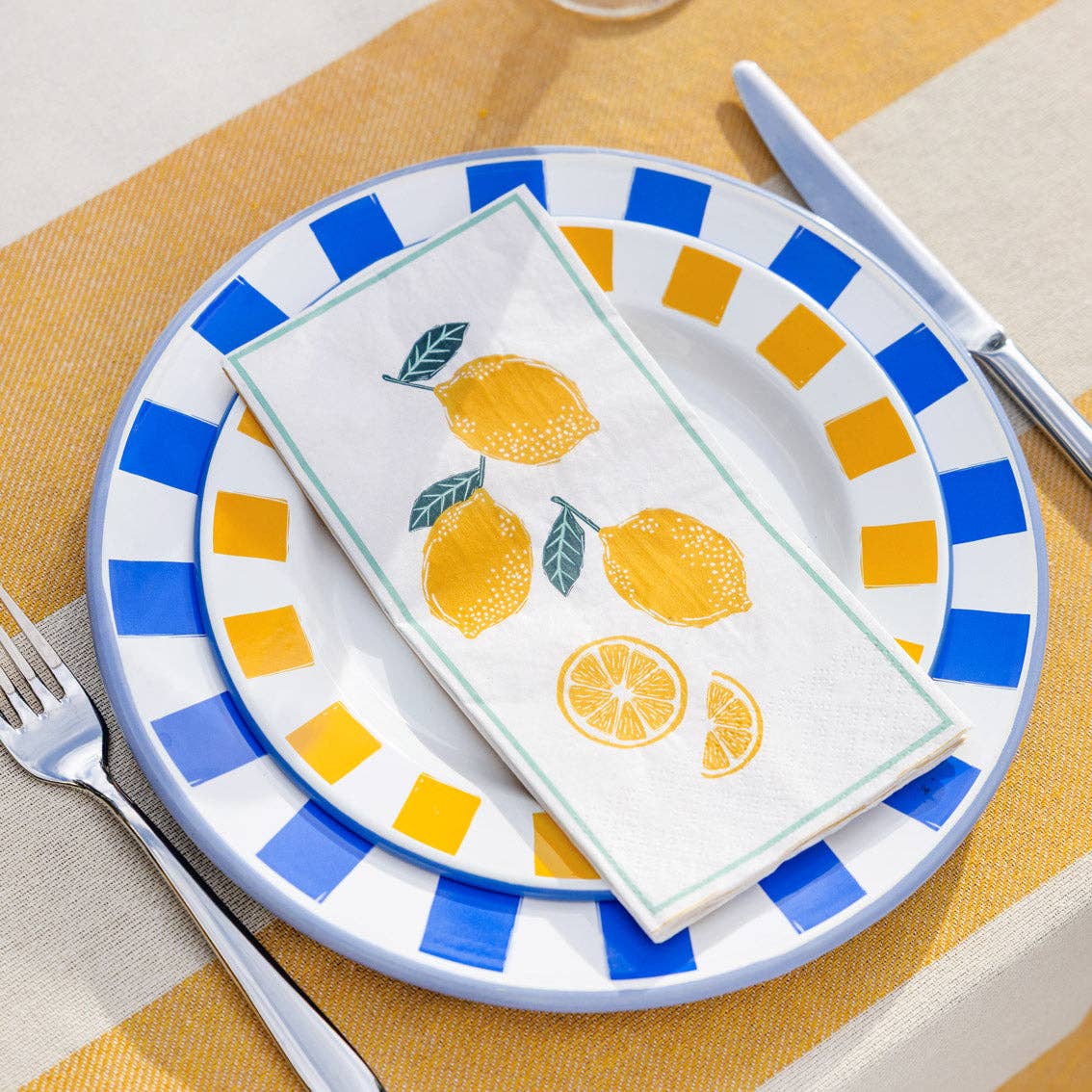 Napkin with lemon design on a plate with blue and yellow pattern