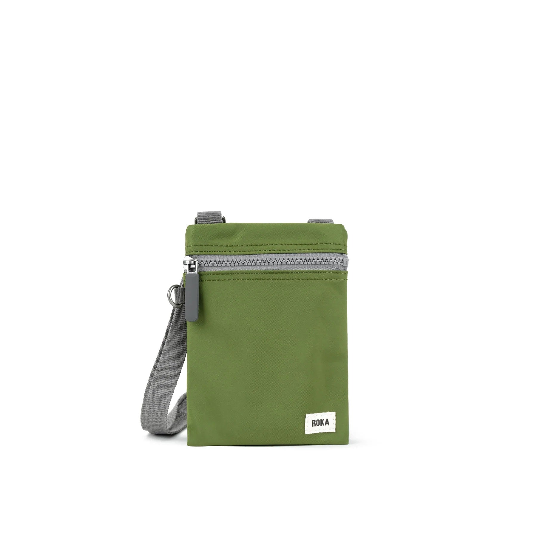 A photo of the front of a small rectangular avocado green pocket bag. It has a grey zip horizontally at the top, grey straps, and a small ROKA logo in the bottom right corner.