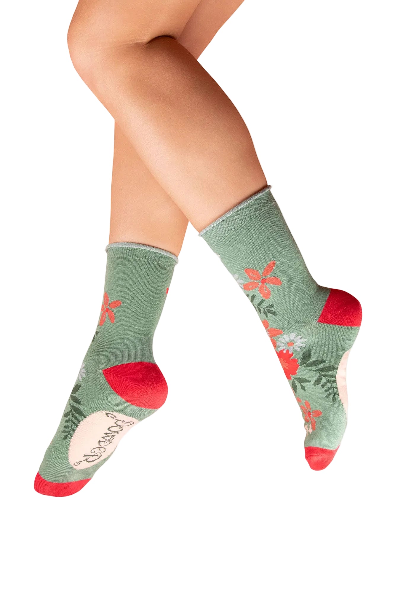 Green socks with floral designs and red accents worn by a person on a white background