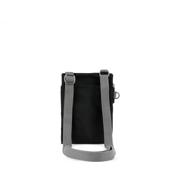 A photo of the back of a small rectangular black pocket bag. It has a pocket and grey straps.