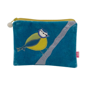 Photo of a small rectangular purse made from blue velvet with a blue, green and yellow bird sitting on a branch appliquéd onto the front.