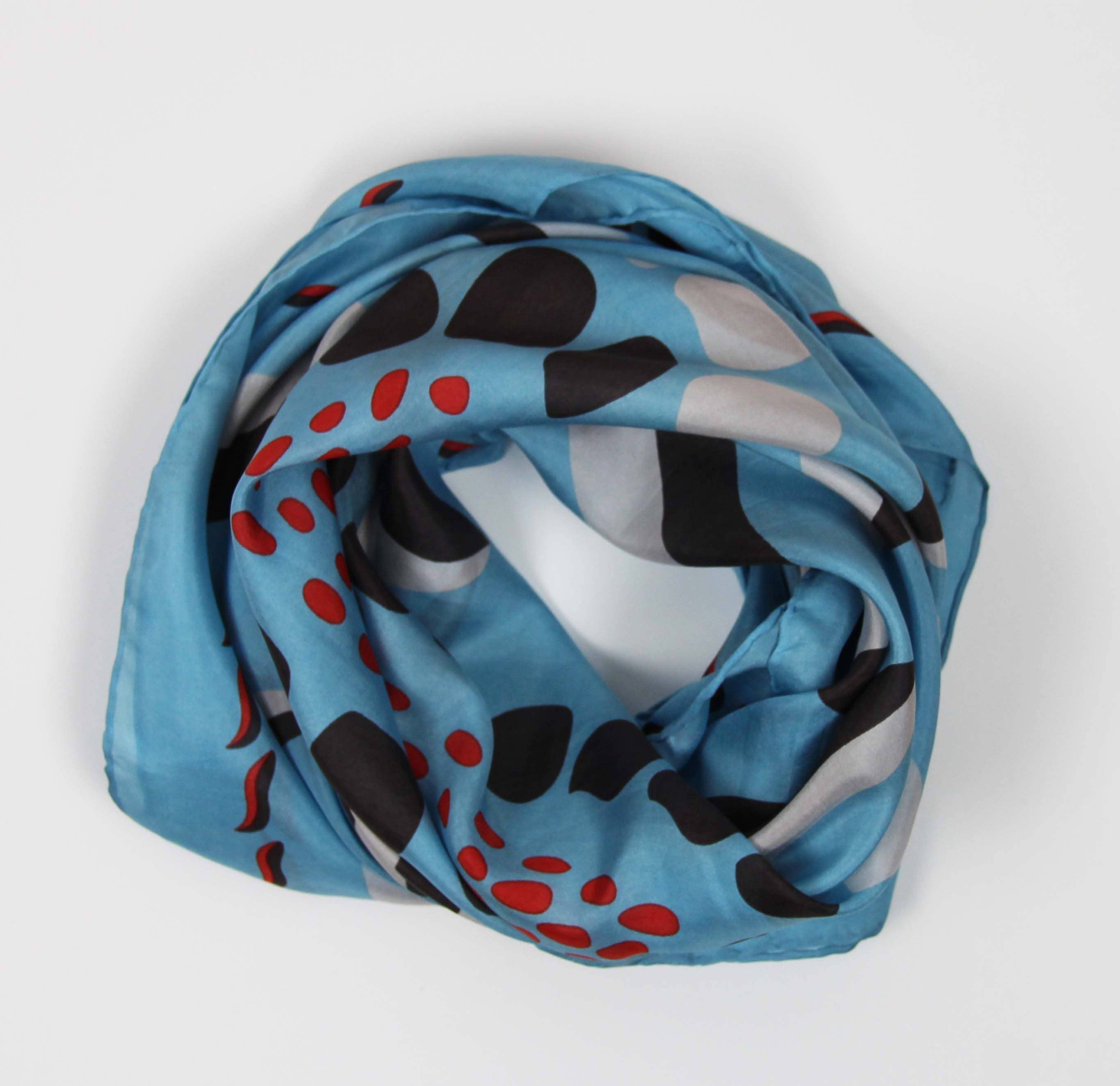Blue scarf with black and red abstract pattern on a white background